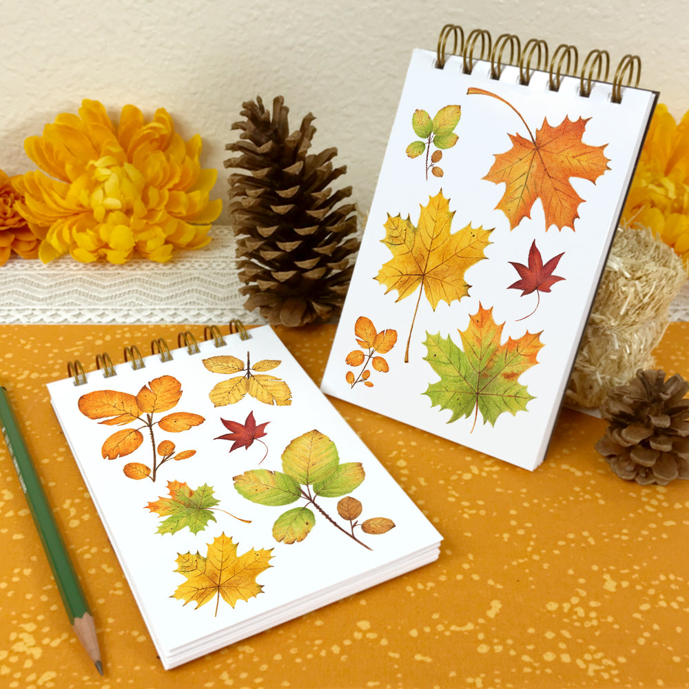 4x6 wire bound notebooks with watercolor paintings of fall leaves on the covers.