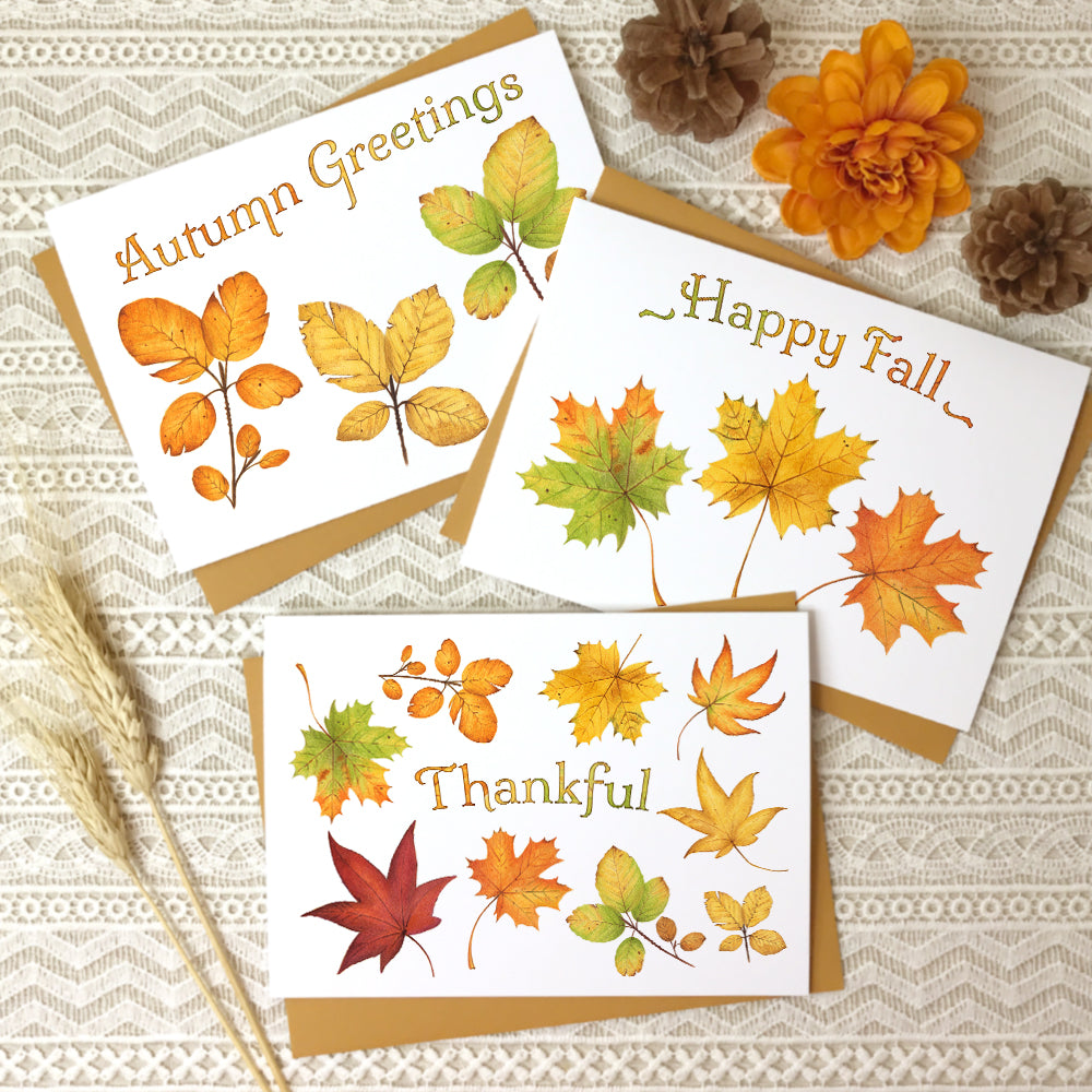 Set of three autumn greeting cards with watercolor paintings of fall leaves titled, "Autumn Greetings", "Happy Fall", and "Thankful".