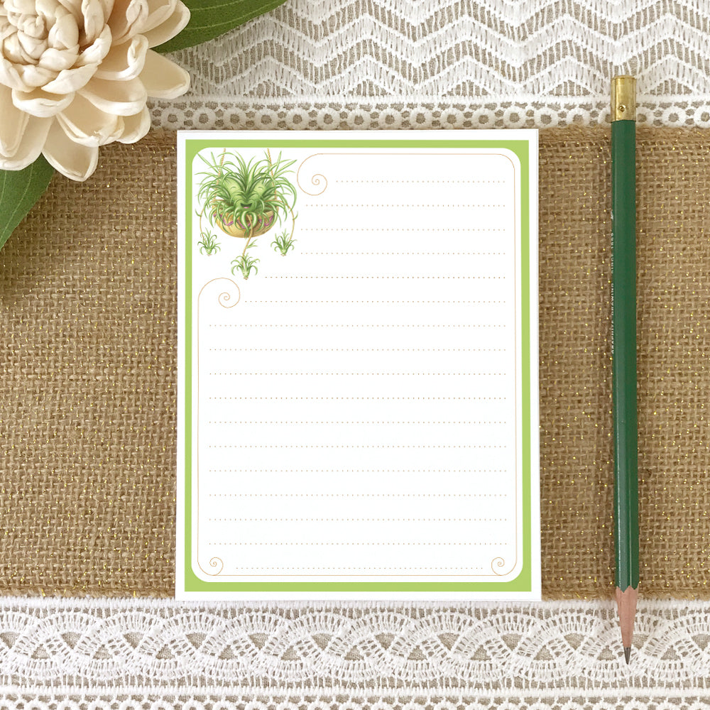 Small lined notepad with illustration of a cute spider plant in upper left corner.